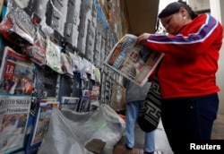 A woman reads a newspaper after the election of Ivan Duque as new Colombian President, in Bogota, Colombia, June 18, 2018.