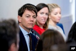 FILE - White House deputy press secretary Hogan Gidley, left, attends the daily briefing in the Brady Press Briefing Room of the White House, Oct. 20, 2017.