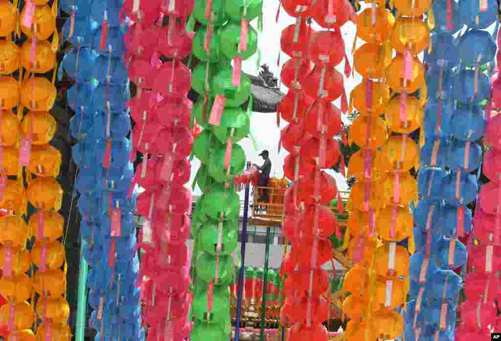 A worker removes lanterns following Buddha&#39;s birthday celebrations at the Chogye Temple in Seoul, South Korea. Similar lanterns are annually displayed in all Buddhist temples around South Korea for the public viewing.