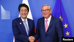 欧盟委员会主席容克在布鲁塞尔与到访的日本首相安倍晋三握手。（2019年9月27日）