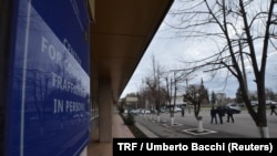 FILE - People walk outside the building housing the headquarters of the Moldova’s anti-trafficking police unit in Chisinau, Moldova, April 6, 2018. 