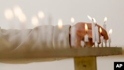 A woman lights a candle to mourn for victims of the March 11, 2011 earthquake and tsunami before a special memorial event in Tokyo, March 11, 2017. Japan marked the sixth anniversary of the 2011 disaster that left more than 18,000 people dead or missing and led to a meltdown at the Fukushima Dai-Ichi nuclear plant.
