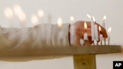 A woman lights a candle to mourn for victims of the March 11, 2011 earthquake and tsunami before a special memorial event in Tokyo, March 11, 2017. Japan marked the sixth anniversary of the 2011 disaster that left more than 18,000 people dead or missing and led to a meltdown at the Fukushima Dai-Ichi nuclear plant.