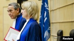 Presiding Judge Bruno Cotte from France (L) and Judge Christine Van Den Wyngaert from Belgium (R) stand during the verdict of the trial of Congolese warlord Mathieu Ngudjolo Chui at the International Criminal Court (ICC) in The Hague, December 18, 2012.