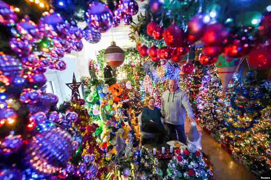 Susanne and Thomas Jeromin, the official world record holders with their 605 decorated Christmas trees in one home, pose for a photo in their house in Rinteln, west of Hanover, Germany, Dec. 3, 2024.