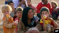 한 시리아 난민 여성이 터키와 접경지역에서 아이들과 휴식을 취하고 있다. 