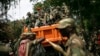 FILE - M23 rebels sit in a vehicle as they withdraw from the eastern Congo town of Goma, Dec. 1, 2012.