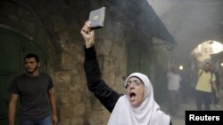 ស្រី្ត​ជនជាតិ​ប៉ាឡេស្ទីន​បាន​ស្រែក​ពាក្យ​ស្លោក​ ខណៈ​កំពុង​លើក​សៀវភៅ​ Koran នៅ​អំឡុង​ពេល​ប៉ះទង្គិច​គ្នា​ជាមួយ​កងកម្លាំង​ប៉ូលិស​អ៊ីស្រាអែល​នៅ​រដ្ឋធានី​ហ៊្សេរុយសាឡិម​នា​ថ្ងៃ​ទី១៣ ខែ​កញ្ញា ឆ្នាំ២០១៥។