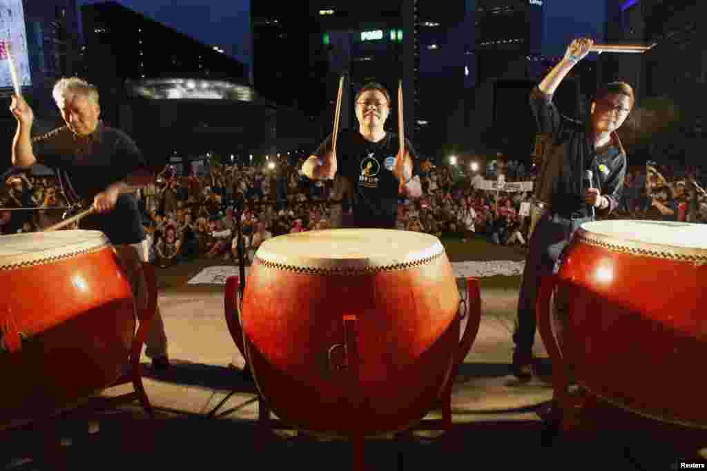 Founders of the Occupy Central civil disobedience movement (L-R), Reverend Chu Yiu-ming, academic Benny Tai and academic Chan Kin-man, hit drums during a campaign to kick off the movement in front of the financial Central district in Hong Kong, Aug. 31, 2014.