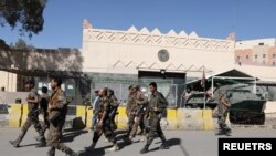 Para tentara pasukan pemberontak Houthi tampak berjalan melewati Kedutaan Besar AS di Sanaa, Yaman, pada 18 Januari 2021. (Foto: Reuters/Khaled Abdullah)