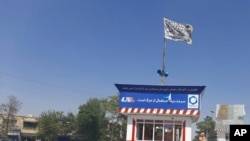 A Taliban flag flies in the main square of Kunduz city after fighting between Taliban and Afghan security forces, in Kunduz, Afghanistan, Aug. 8, 2021. 