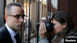 Olympic and Paralympic track star Oscar Pistorius (L) arrives ahead of his trial for the murder of his girlfriend Reeva Steenkamp, at the North Gauteng High Court in Pretoria, May 13, 2014.