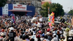 Cambodia's factory workers and members of the country's main opposition Cambodia National Rescue Party, cheer as opposition leader Sam Rainsy arrived at a street near Freedom Park in Phnom Penh, Cambodia, Thursday, May 1, 2014. 