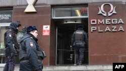 FILE - Russian police officers gather at the entrance to a business center housing the office of opposition leader Alexei Navalny's Anti-Corruption Foundation (FBK), in Moscow, Russia, Jan. 28, 2018.