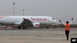 Un aiguilleur de l’air dirige un avion de Senegal Airlines à l’aéroport international de Dakar, Sénégal (archives)