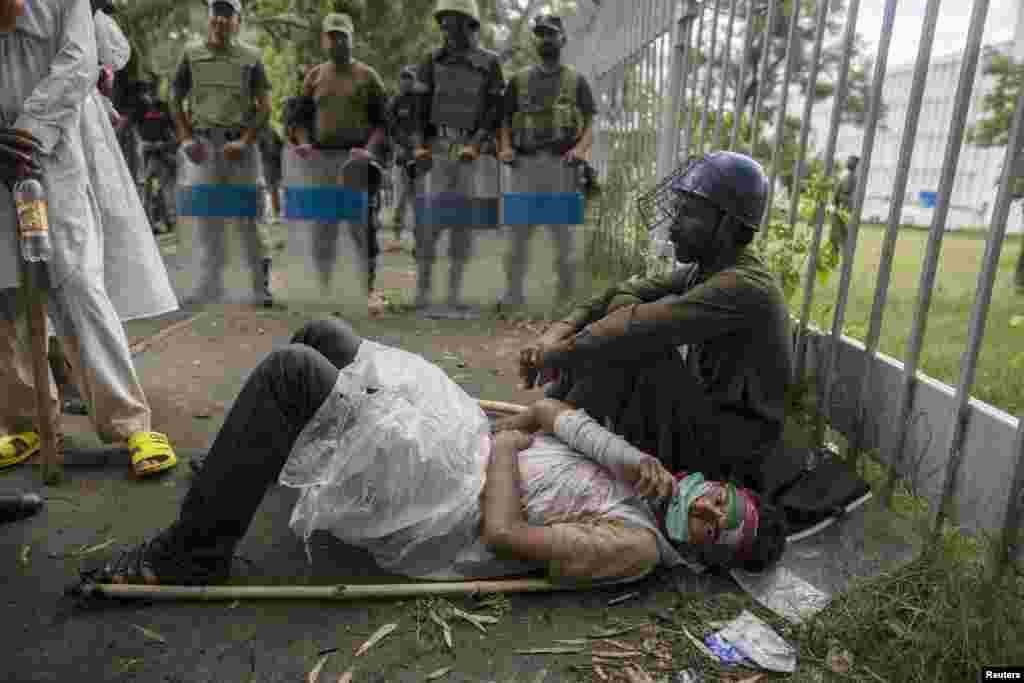 A woman lies on the ground while soldiers from the Pakistan Rangers block a road leading to Prime Minister Nawaz Sharif's house, Islamabad Sept. 1, 2014.