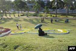 FILE - People rest at the Inya Lake Park in Yangon, Dec. 28, 2016.