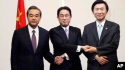 រដ្ឋ​មន្ត្រី​ការបទេស​ជប៉ុន Fumio Kishida (កណ្តាល) រដ្ឋ​មន្ត្រី​ការបរទេស​ចិន Wang Yi (ឆ្វេង) និង​រដ្ឋ​មន្ត្រី​ការ​បរទេស​កូរ៉េ​ខាង​ត្បូង Yun Byung-se ថត​រូប​មុន​ពេល​​ពិធី​ទទួល​ទាន​អាហារ​ពេល​ល្ងាច មុន​ពេល​កិច្ច​ប្រជុំ​ផ្លូវ​ការចាប់​ផ្តើម​នៅថ្ងៃ​នេះ។