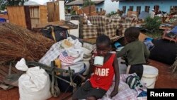 Zimbabwean children sit among salvaged possessions at a transit camp for over 100 families displaced by floods near the Tokwe-Mukorsi dam about 430km (267 miles) south of Harare, Feb. 13, 2014.