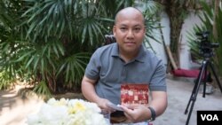 លោកឡុង ឌីម៉ង់ ឯកអគ្គរាជទូតខ្មែរប្រចាំប្រទេសកូរ៉េខាងត្បូងកំពុងតែរើសបង្ហាញរូបថតចាស់ៗរបស់លោក នៅក្នុងផ្ទះរបស់លោក បន្ទាប់កិច្ចសម្ភាសន៍ផ្តាច់មុខជាមួយ VOA កាលពីថ្ងៃទី១៣ ខែមេសា ឆ្នាំ២០១៦។ (នៅ វណ្ណារិន/VOA) 