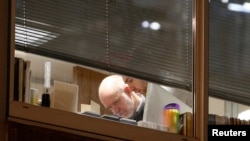 People are seen inside the building which houses the offices of Cambridge Analytica as investigators from Britain's Information Commissioners Office entered, following the granting of a search warrant by a High Court judge, in London, March 23, 2018.