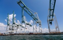 FILE - Large cranes used to unload container ships are shown at Port Miami in Miami, July 24, 2019.
