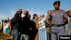 FILE - A police officer looks on at a voting station during the Lesotho national election in Magkhoakhoeng village outside the capital Maseru , Feb. 28, 2015. 