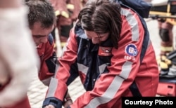 Paramedics treat a patient at the scene of a car crash. They often try to save the lives of people injured in drunken-driving incidents. (Credit: JPSA)