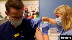 FILE - Fourth-year medical student Anna Roesler administers the Pfizer-BioNTech coronavirus vaccine at Indiana University Health, Methodist Hospital in Indianapolis, Indiana, U.S., December 16, 2020. (REUTERS/Bryan Woolston/File)