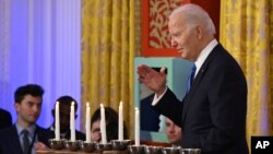 조 바이든(오른쪽) 미국 대통령이 11일 백악관 이스트룸에서 '하누카' 리셉션 도중 메노라(유대교 촛대) 옆을 지나며 손키스를 날리고 있다. 하누카는 성전 촛대의 불꽃이 하루치 기름으로 8일간 타오른 기적을 기리는 유대교 명절이다. 지난 7일 시작됐다. 