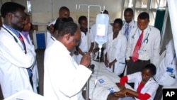 Likitoci da maikatan asibiti suna duban mai ciwo