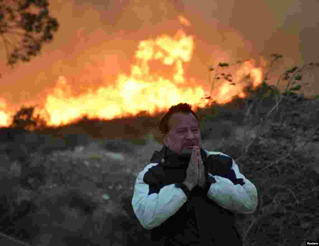 A local man prays during an early-morning Creek Fire that broke out in the Kagel Canyon area in the San Fernando Valley north of Los Angeles, in Sylmar, Dec. 5, 2017.