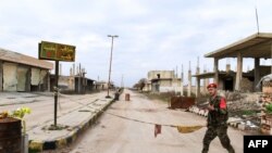 Tentara Suriah berpatroli di kota Tall Sultan, dekat papan bertuliskan "Saraqeb", barat laut provinsi Idlib, Suriah, 5 februari 2020. (Foto: dok). 