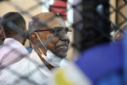 FILE - Sudan's ousted president Omar al-Bashir sits at the defendant's cage during his trial, at a courthouse in Khartoum, Sudan, Sept. 15, 2020.