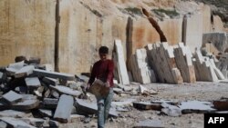 Aqeel Othman, seorang anak pengungsi Suriah berusia 13 tahun, membawa balok batu di tambang tempatnya bekerja di pinggiran al-Dana, Provinsi Idlib, wilayah barat laut yang dikuasai pemberontak, pada 14 Maret 2024. (Foto: AFP)