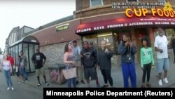 នាង Darnella Frazier (ទីបីរាប់​ពី​ស្ដាំ) ប្រើ​ទូរស័ព្ទ​ដៃ​របស់​ខ្លួន​ដើម្បី​ថត​សកម្ម​ដែល​ប៉ូលិស​កំពុង​ចាប់​ខ្លួន​លោក George Floyd នៅ​ក្នុង​រូបថត​មួយ​ដែល​ត្រូវ​បាន​ដកស្រង់​ចេញ​ពី​វីដេអូ​កាមេរ៉ា​របស់​ប៉ូលិស​ក្រុង Minneapolis រដ្ឋ Minnesota សហរដ្ឋ​អាមេរិក ថ្ងៃទី២៥ ខែឧសភា ឆ្នាំ២០២០។ 