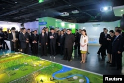 Pemimpin Korea Utara Kim Jong-un dan istrinya Ri Sol Ju, mengunjungi pameran di Beijing, China, 28 Maret 2018. (Foto: KCNA/dok)