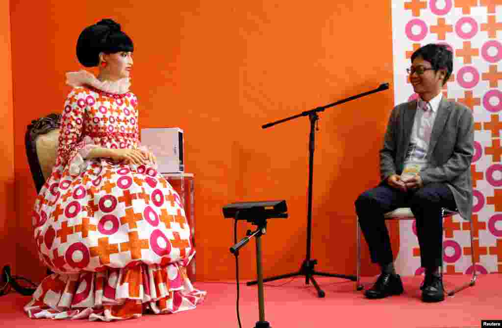 A visitor talks with the android robot &#39;totto&#39;, which was modeled form Japanese TV personality Tetsuko Kuroyanagi, during its demonstration at World Robot Summit in Tokyo.