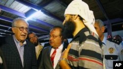 U.N. Syria envoy Lakhdar Brahimi, tasked with ending the 18-month conflict, left, speaks with refugees in Altinozu, Hatay, southern Turkey, Sept. 18, 2012.