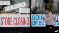 បុរស​ម្នាក់​​ដើរ​កាត់​ហាង​ដែល​​​បាន​បាន​បិទ​ដោយ​សារ​វិបត្តិ​ជំងឺ​កូវីដ១៩​នៅ​ទី​ក្រុង Niles រដ្ឋ Illinois កាល​​ពី​ថ្ងៃ​ទី​២១ ខែ​ឧសភា​ ឆ្នាំ​២០២០។ 