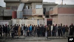 Warga Irak yang mengungsi dari Mosul barat antri untuk menerima pembagian makanan, Selasa (14/3).
