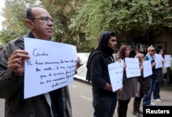 FILE - Activists hold placards that read, among others, "Giulio, one of us and killed like us," during a memorial for Giulio Regeni outside of the Italian embassy in Cairo, Egypt, Feb. 6, 2016.
