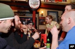 Para mahasiswa menikmati bir di sebuah pub di Cambridge, Massachusetts, 24 Maret 2002. (Foto: AP)