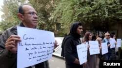 Activists hold placards that read, among others, "Giulio, one of us and killed like us," during a memorial for Giulio Regeni outside of the Italian embassy in Cairo, Egypt, Feb. 6, 2016. 