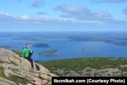 Mikah Meyer sits on Cadillac Mountain, the highest point along the U.S. east coast.
