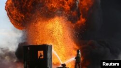 FILE - Firefighters and engineers battle fires at oil wells set ablaze by Islamic State militants before fleeing the oil-producing region of Qayyara, Iraq, Jan. 18, 2017. 
