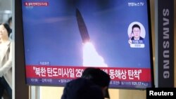 Люди смотрят по телевизору новостной репортаж о том, как Северная Корея запустила несколько ракет малой дальности в Сеуле, Южная Корея, 14 января 2025 года.