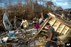 Affected by Hurricane Irma people seek to save their belongings in their destroyed house in Isabela de Sagua, Cuba, Sept. 11, 2017.