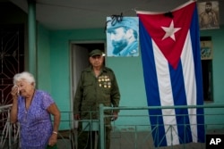 Bertha Socarras, 91, wipes away tears as she recalls the time she personally waited on the late Cuban leader Fidel Castro, as a waitress in Camaguey, Cuba, Dec. 1, 2016, as Castro's four-day funeral procession continues eastbound to Santiago.