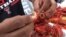 Removing the crawfish tail — it's the best part to eat. (G. Flakus/VOA)